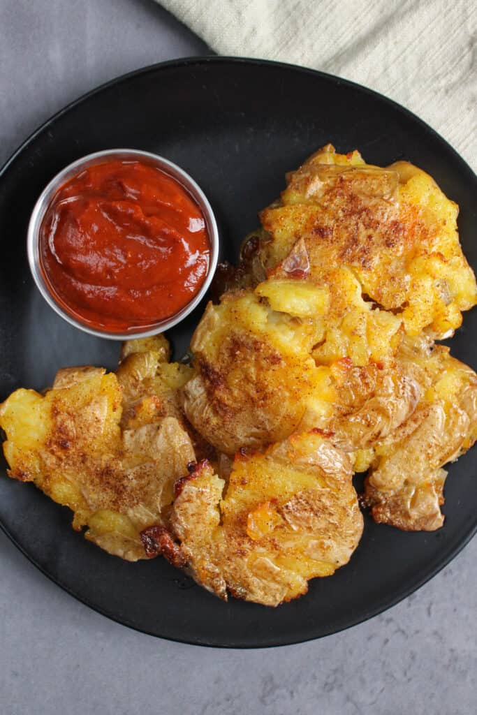 Smashed potatoes and hot sauce for dipping.