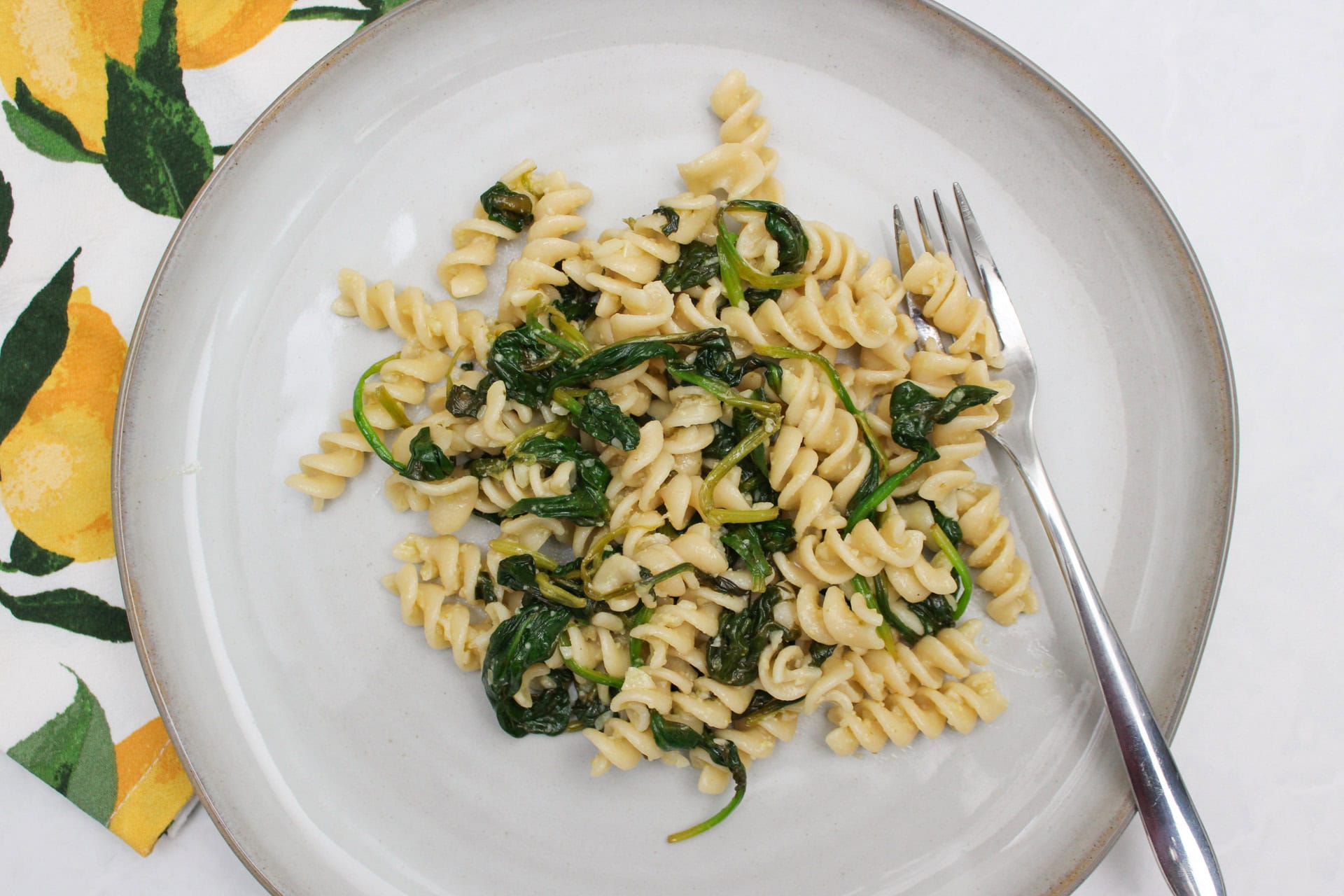 A plate of pasta with spinach.