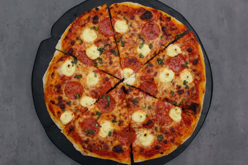 A pepperoni pizza with ricotta and hot honey.