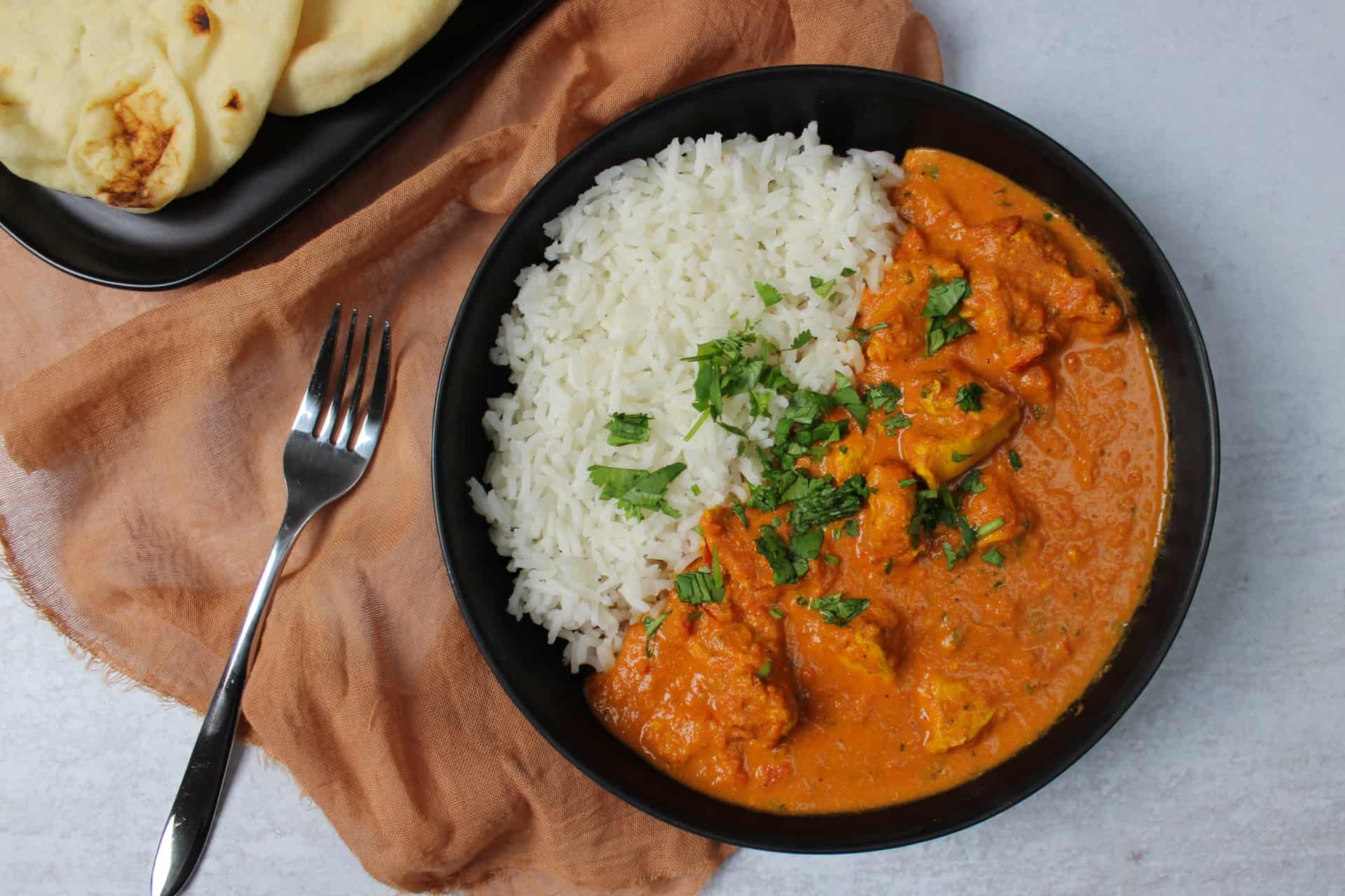 Spicy Indian butter chicken with rice and naan.