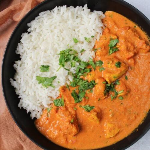 A bowl of spicy butter chicken and rice.