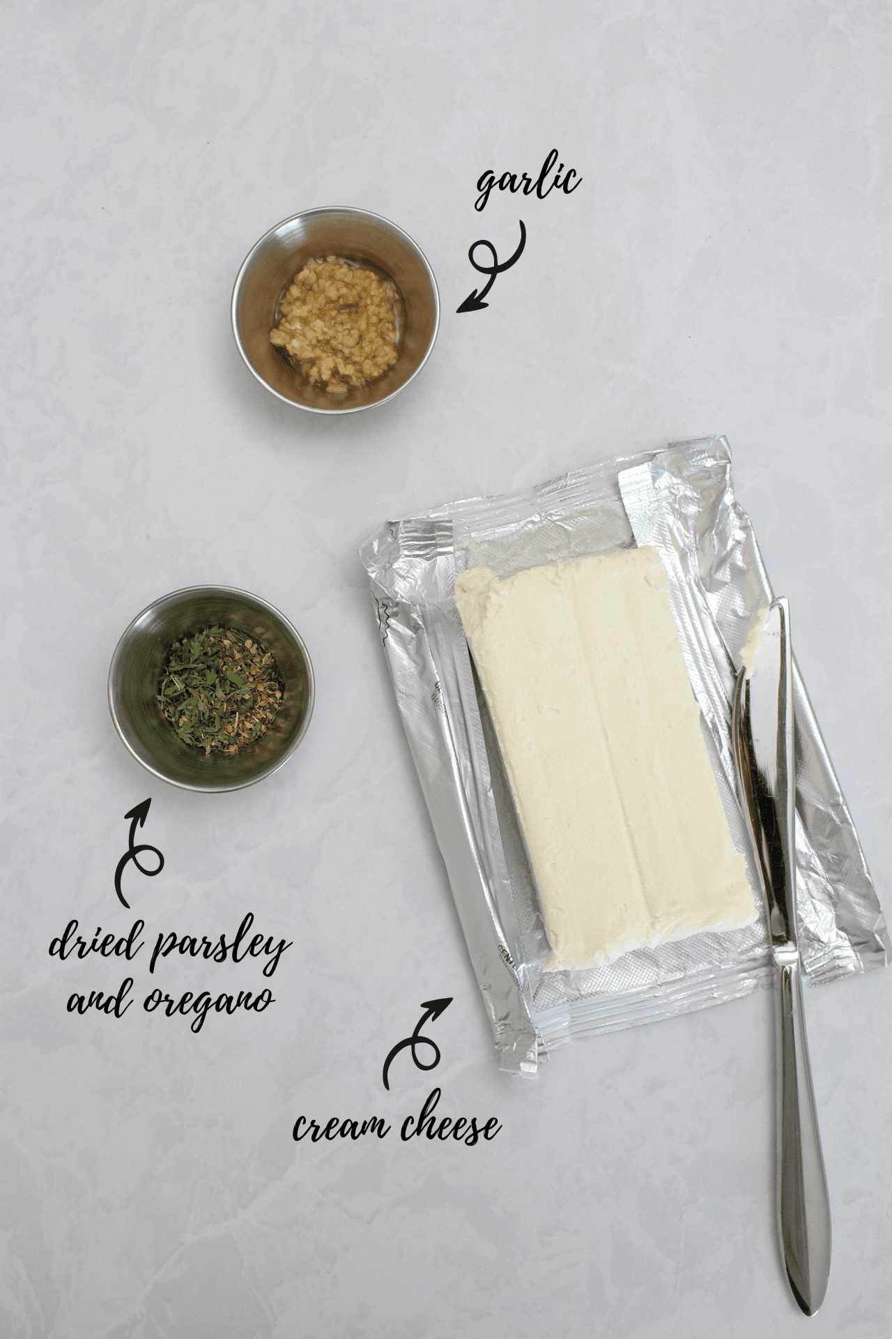 Ingredients for garlic herb cream cheese: garlic, dried parsley and oregano, and cream cheese.