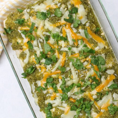 A tray of chicken enchiladas with verde sauce.