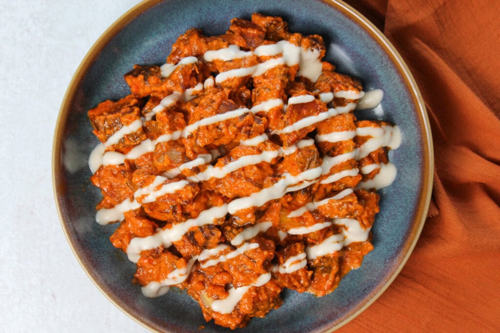 A tapas dish of spicy potatoes in creamy sauce.