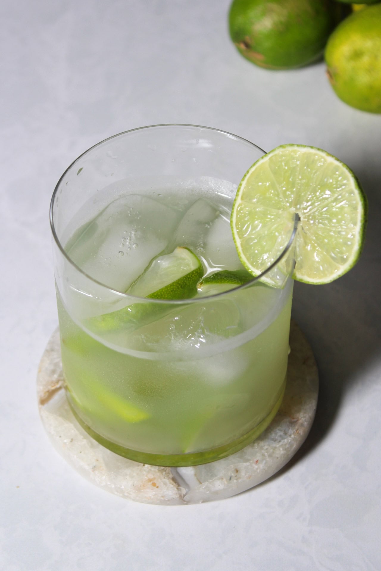A fresh lime caipirinha cocktail with rum and sugar.