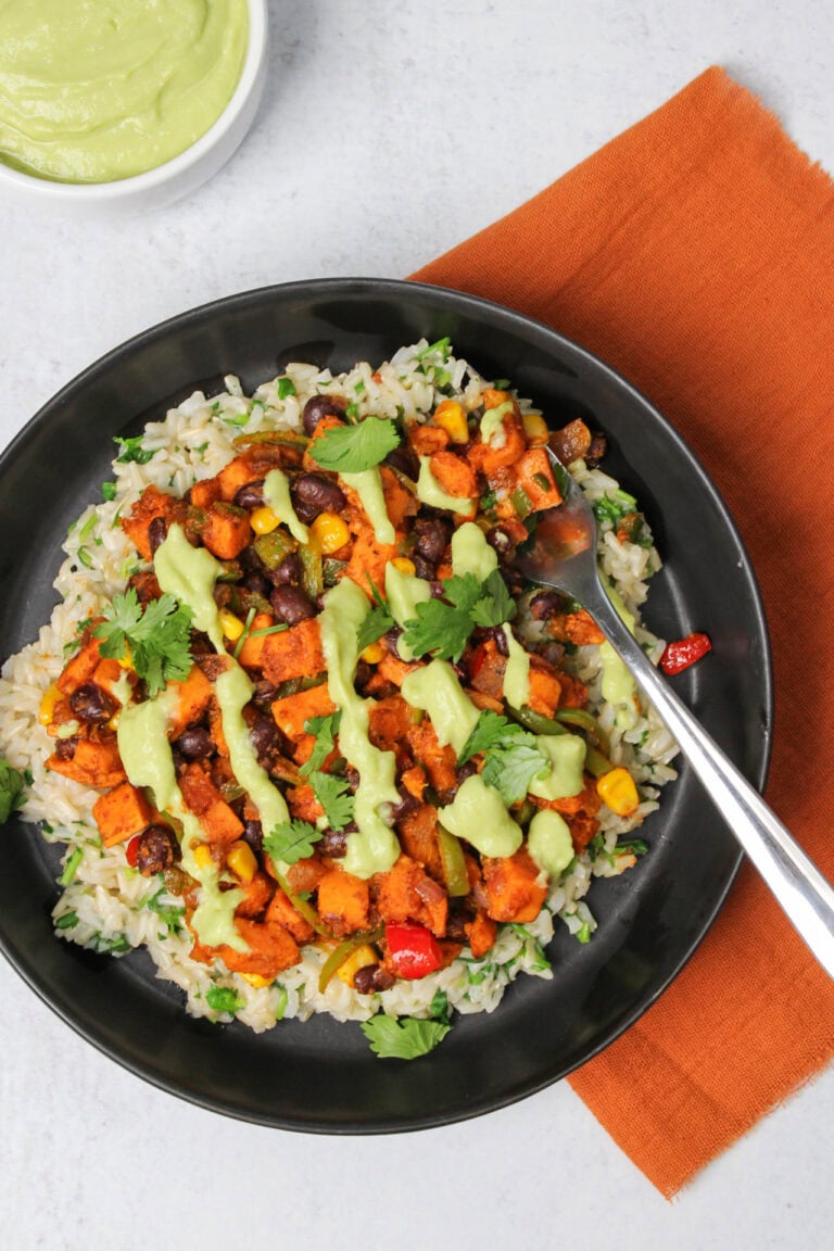 Vegetarian taco bowl with sweet potatoes and avocado crema.