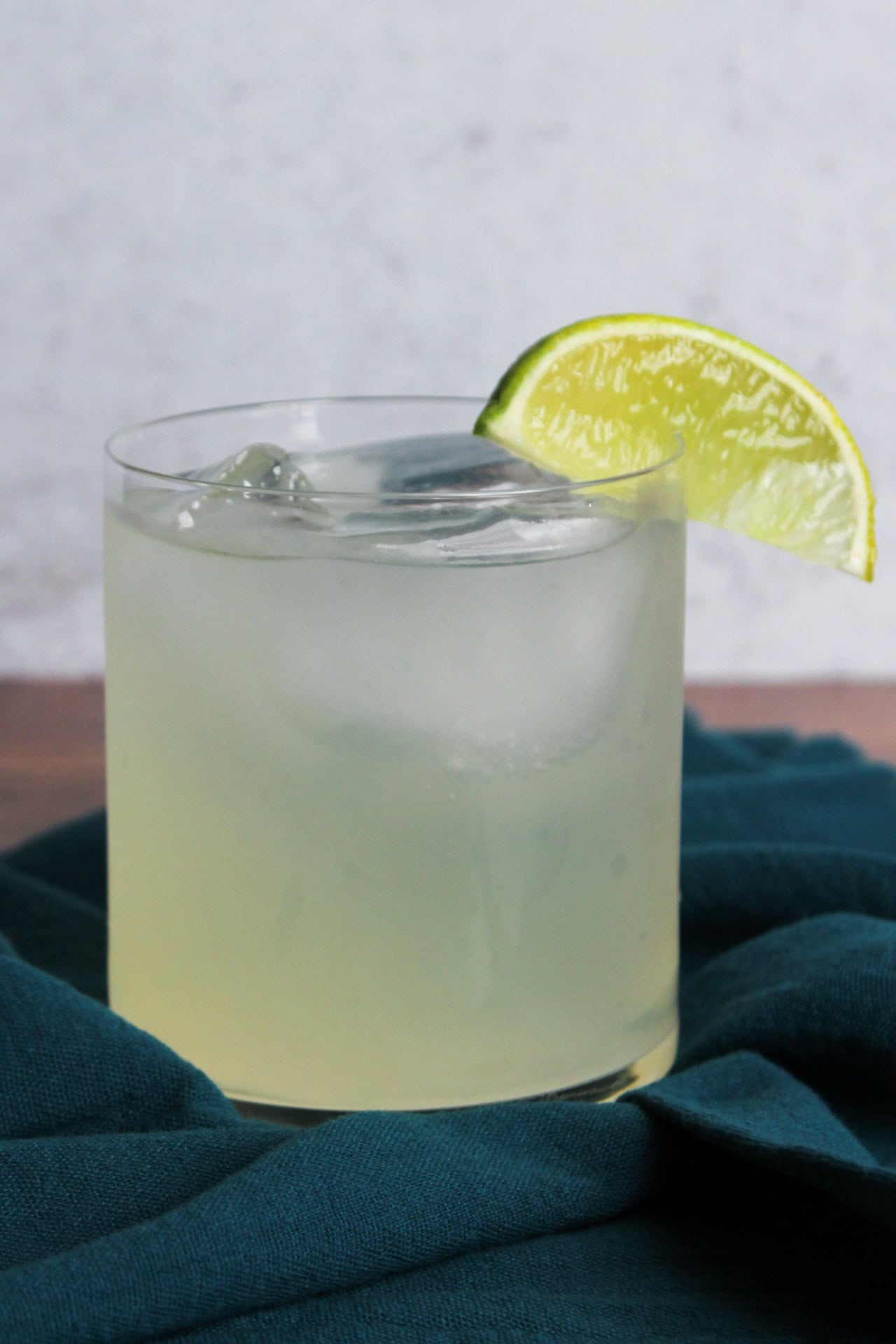 A gin moscow mule served in a rocks glass with a lime wedge.