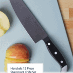Cover Image for Henckels 12 Piece Statement Knife Block showing a chef's knife on a blue cutting board with a sliced apple.