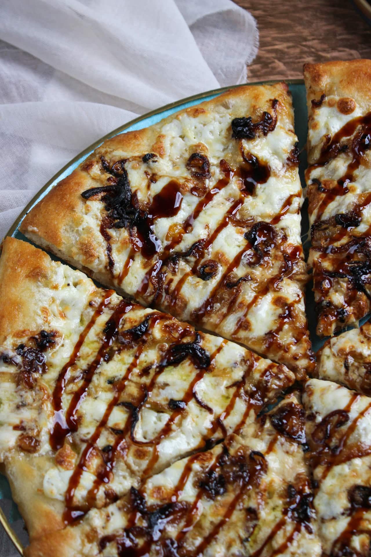 Cheesy white burrata pizza with a zig-zag drizzle of balsamic glaze. 