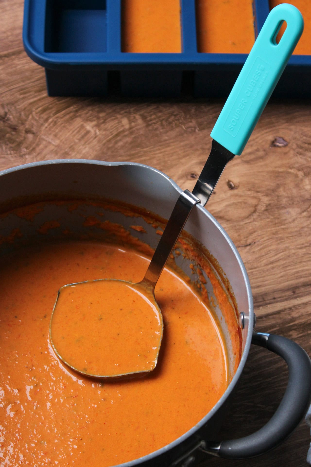 Souper Cubes no mess ladle in a pot of tomato soup.