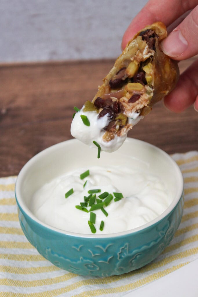 Southwest egg roll dipped into lime crema.