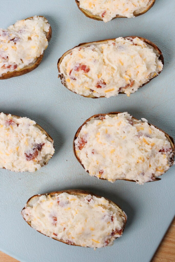 Filled baked potato halves before baking again.