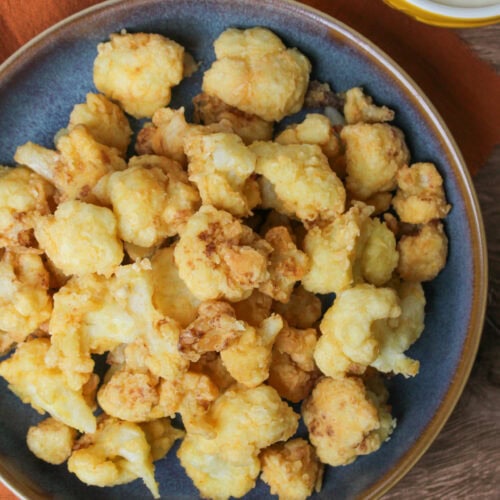 A bowl of fried cauliflower florets.