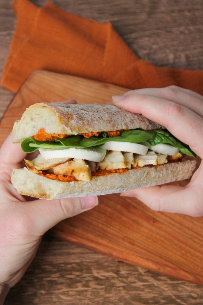 A grilled chicken sandwich with sun-dried tomato pesto, spinach, and mozzarella.