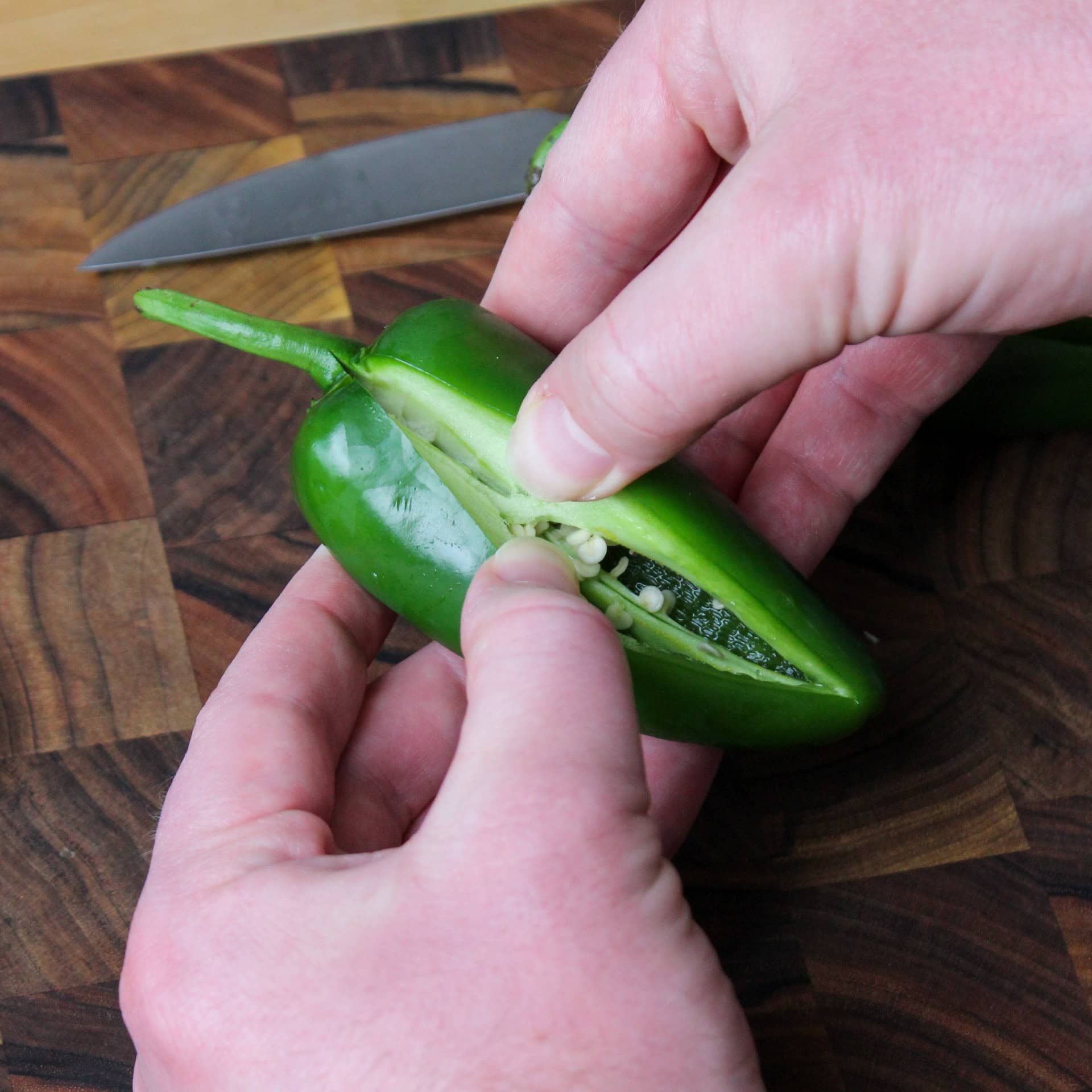 Opening up a jalapeno pepper.