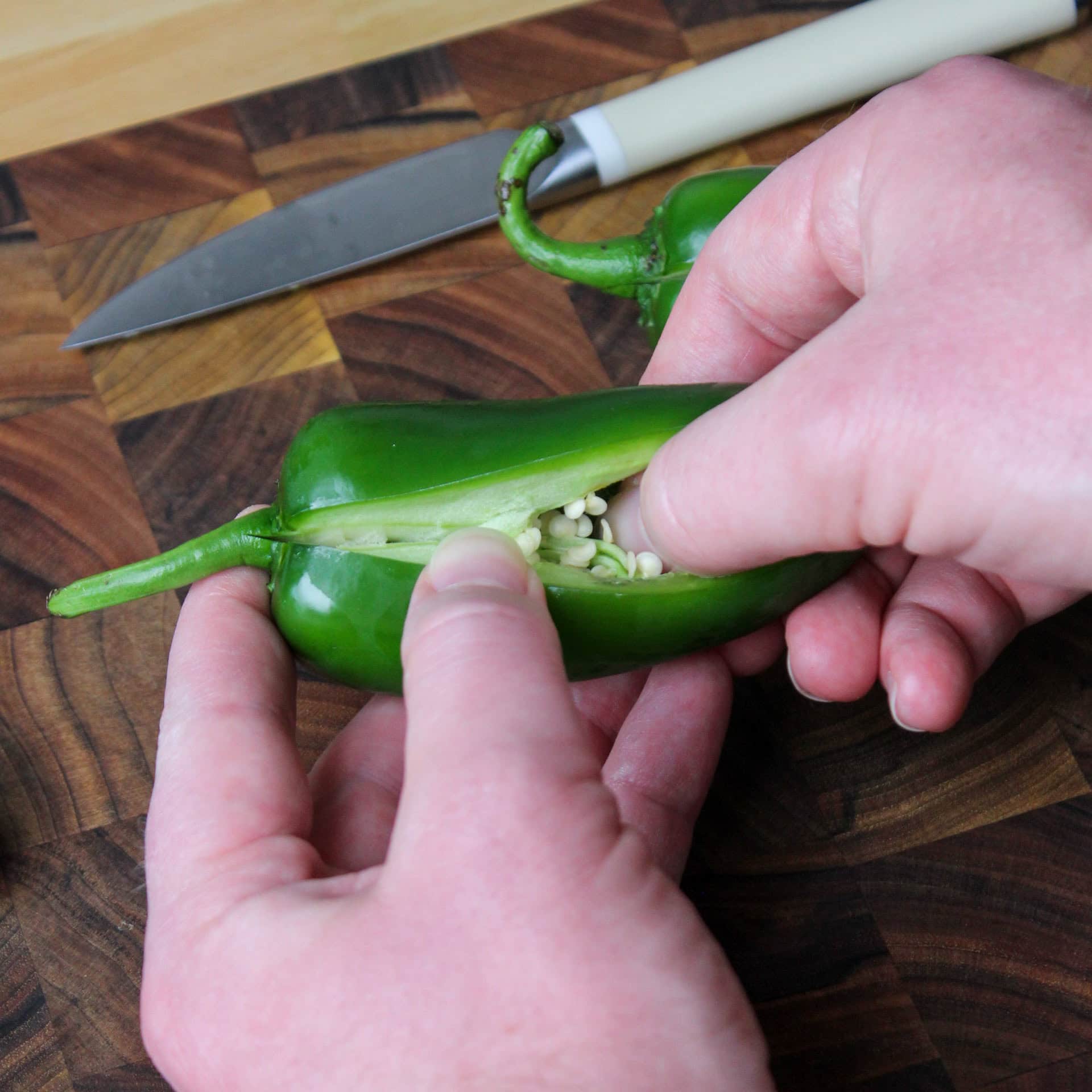 Coring and de-seeding a jalapeno pepper.