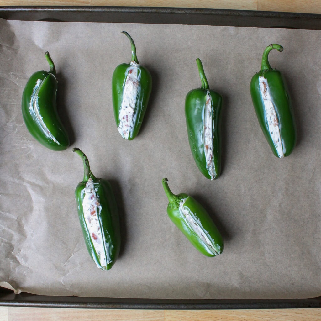 Jalapeno poppers on a baking sheet.