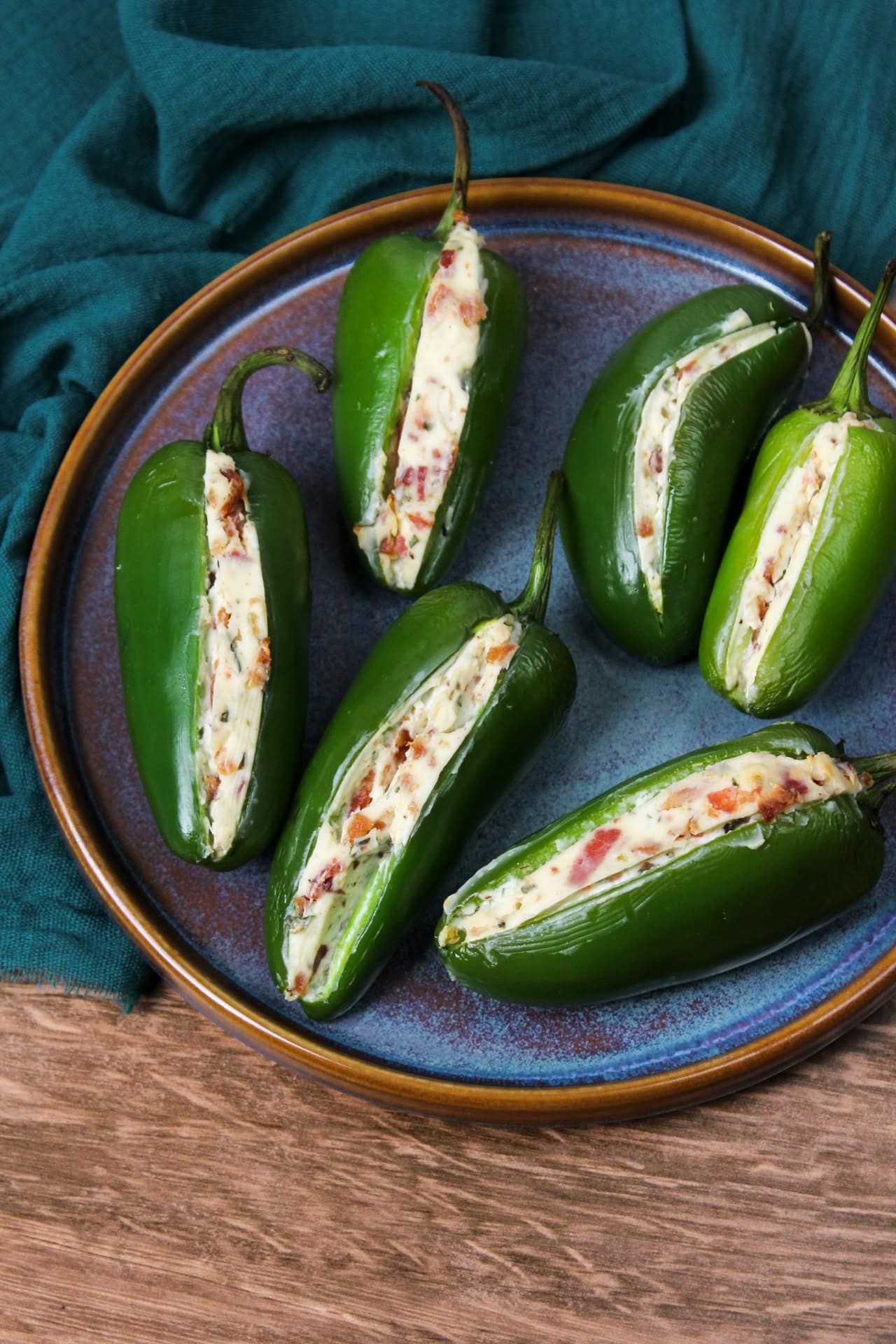 Cream cheese jalapeno poppers served on a blue stoneware plate.