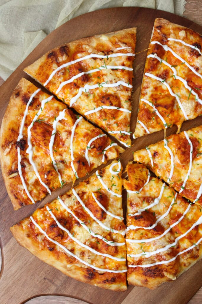 An Indian fusion butter chicken pizza with yogurt drizzle.