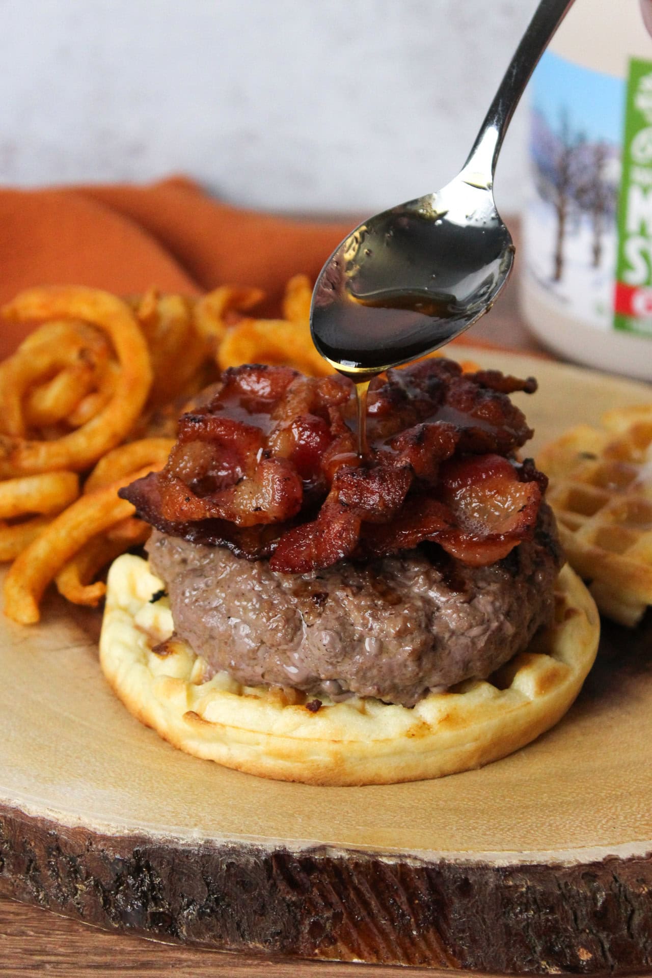 A burger with maple bourbon syrup and maple bacon served on a waffle.