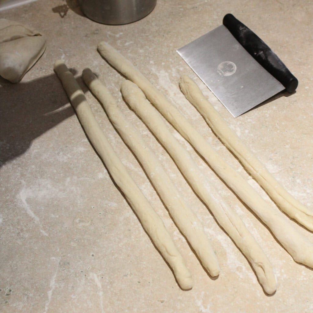 Pizza dough snakes for making soft pretzel bites.