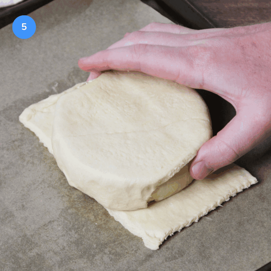 Flipping the brie over to encase the other side in pastry dough.