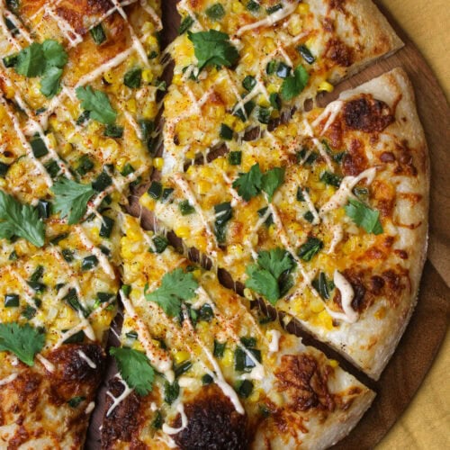 An elote inspired pizza topped with corn and peppers.