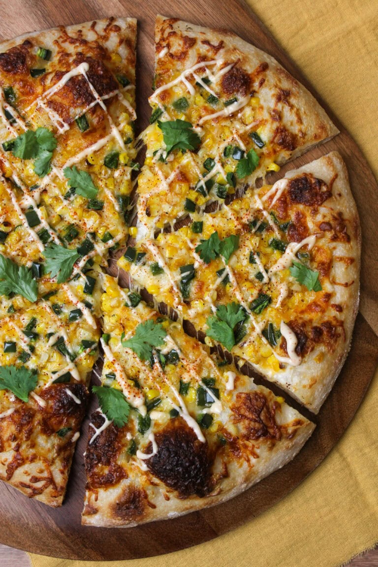 An elote inspired pizza topped with corn and peppers.