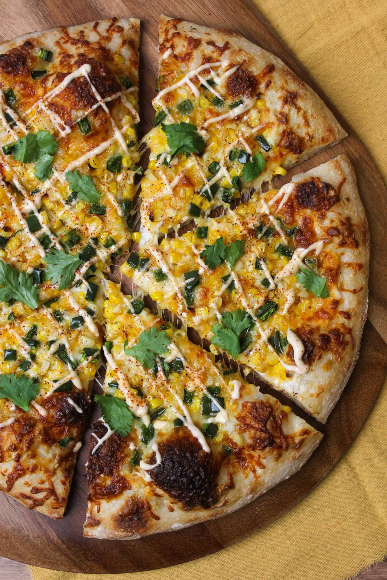 An elote inspired pizza topped with corn and peppers.