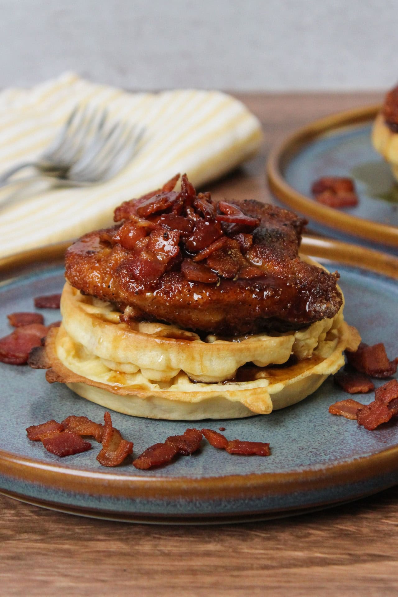 Crispy fried chicken and waffles with bacon and maple syrup.