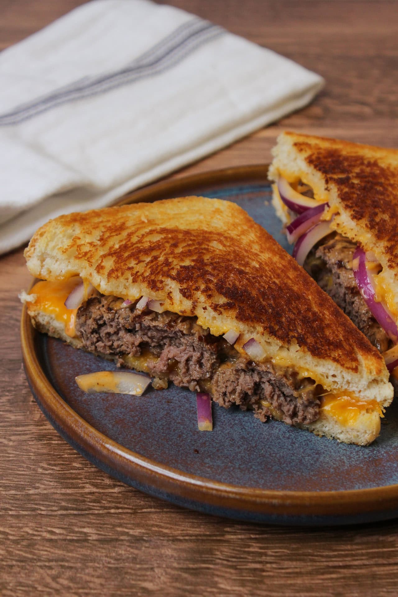 A grilled cheese burger, or patty melt, made with sourdough, cheddar cheese, red onion, and chipotle mayo.