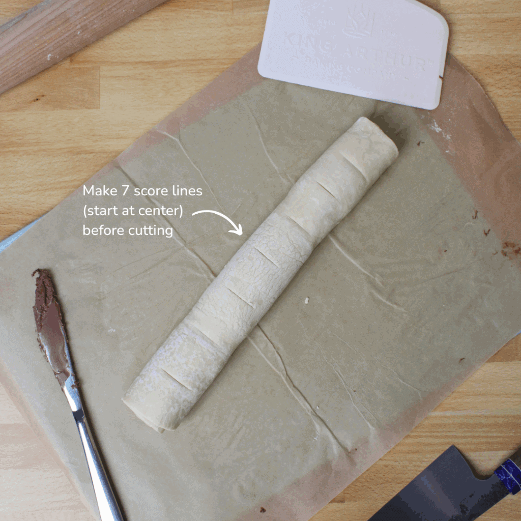 Rolled up puff pastry with score lines.