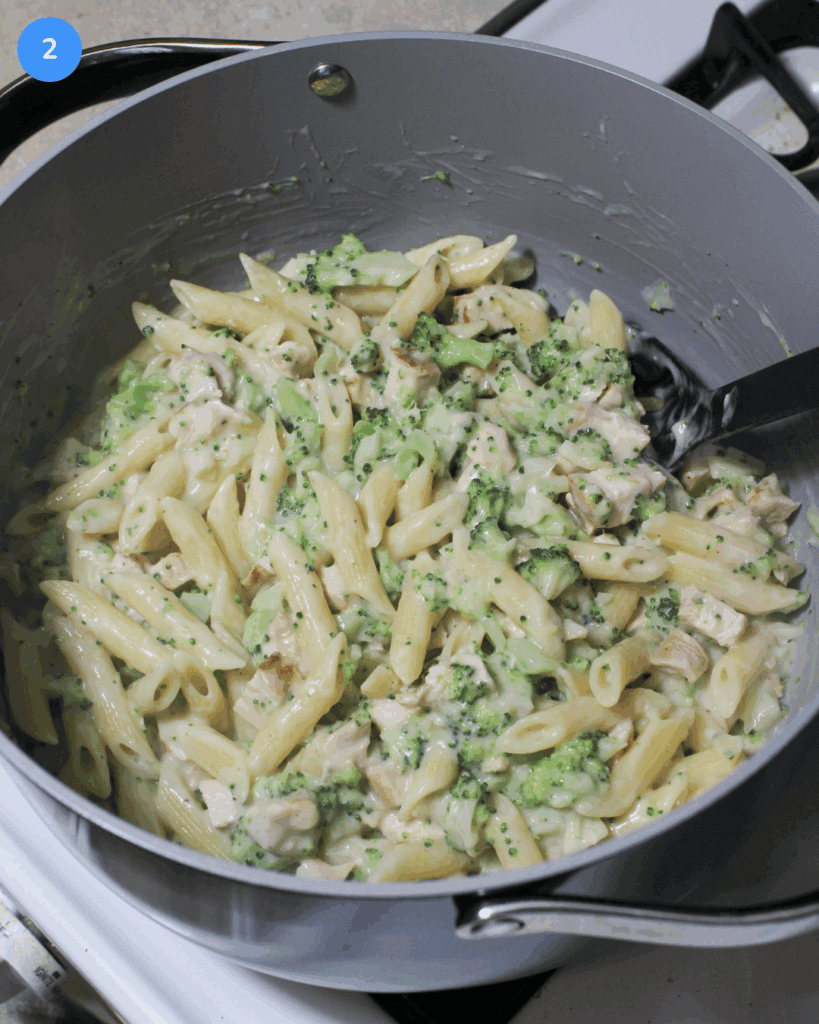 Chicken broccoli pasta in a large pot on the stove.