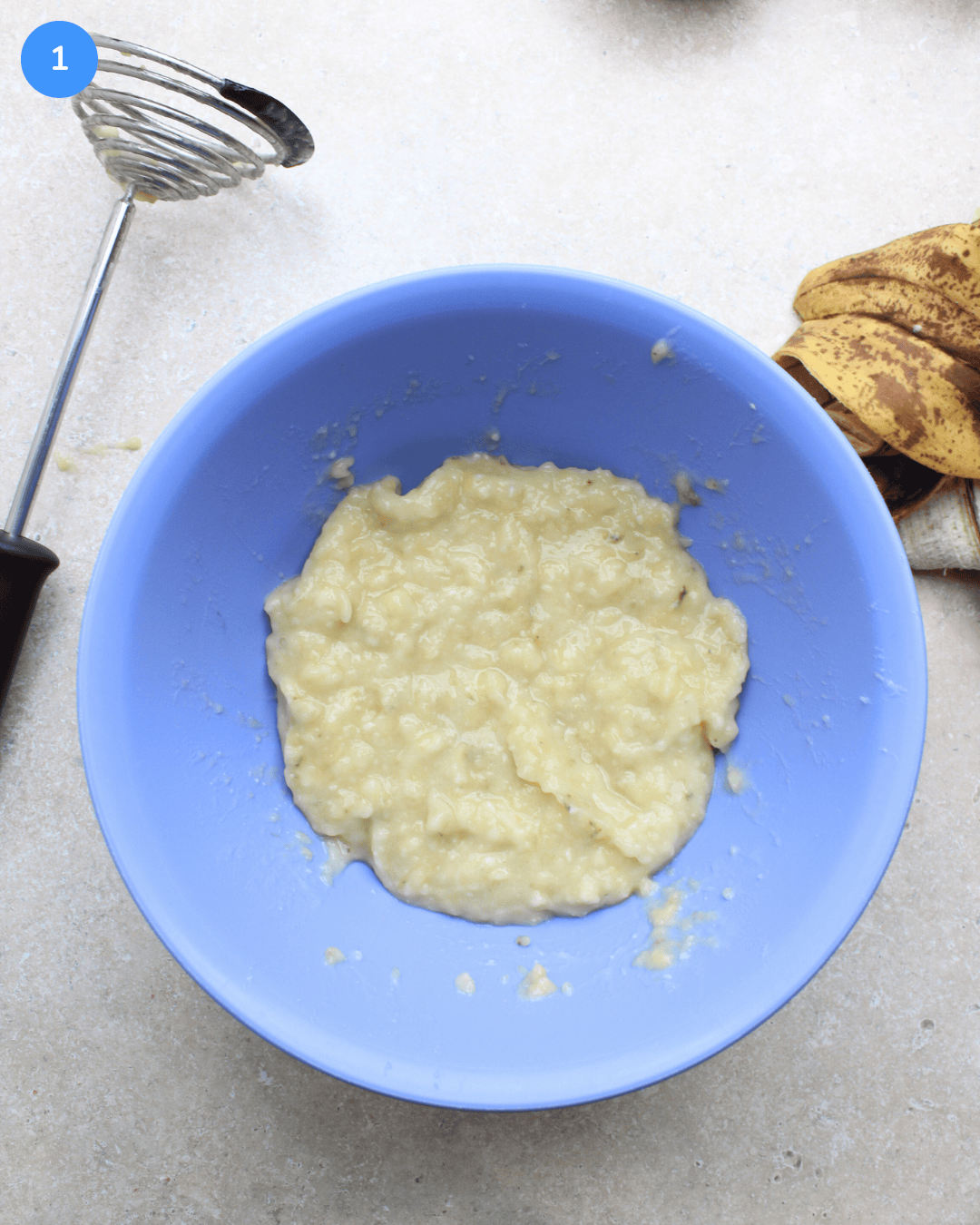Mashed banana in a blue bowl.