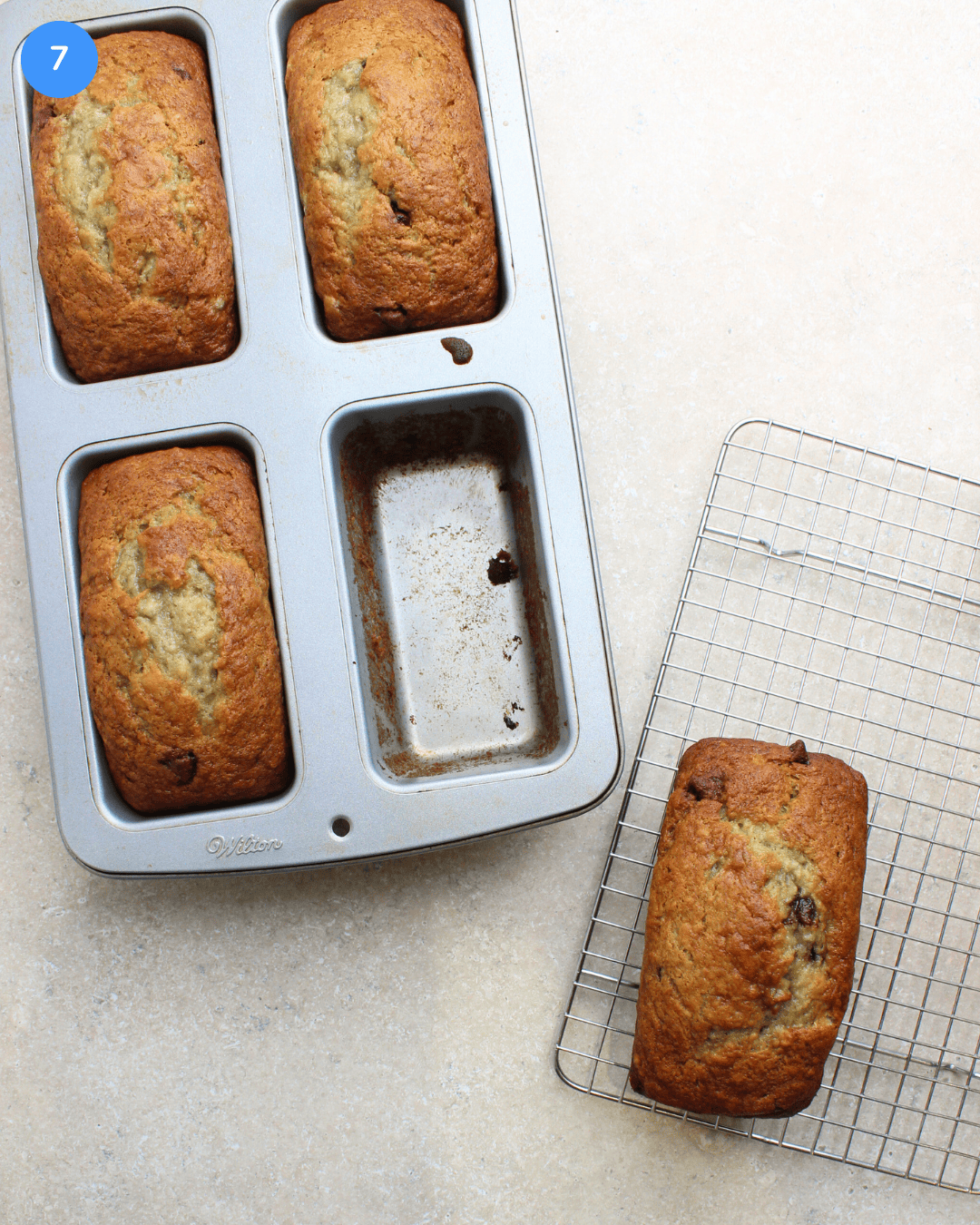 3 mini banana bread loaves in a pan and one loaf on a wire cooling rack.