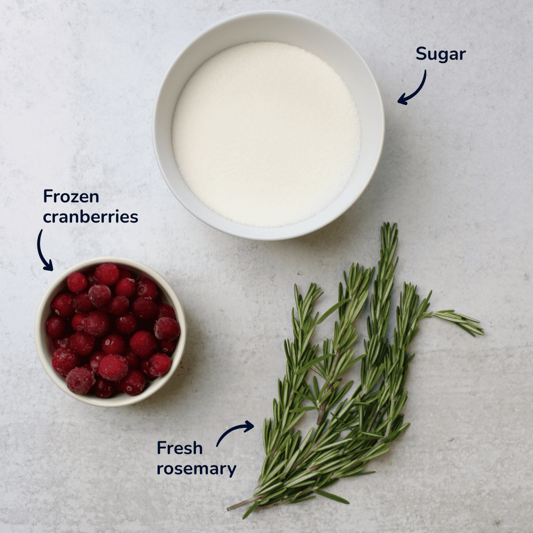 Ingredients for cranberry rosemary simple syrup: sugar, frozen cranberries, and fresh rosemary.