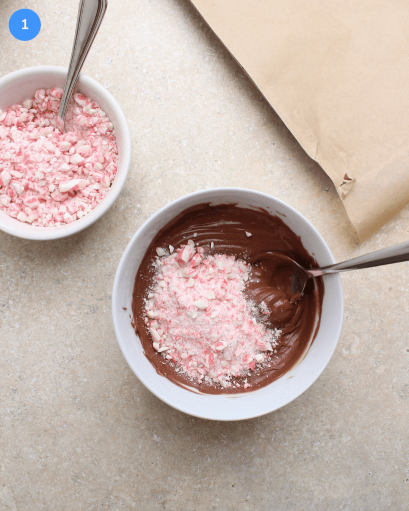 A bowl of melted milk chocolate with crushed candy canes.