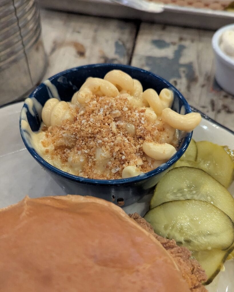 A small blue bowl of creamy mac n cheese topped with breadcrumbs.