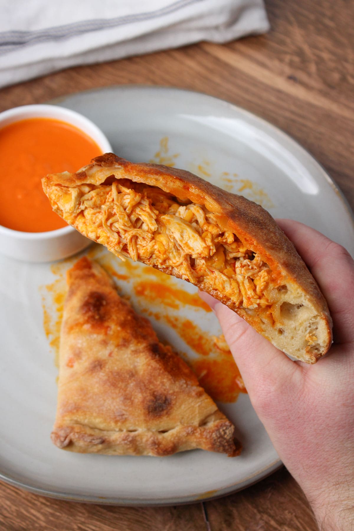 A crispy buffalo chicken calzone filled with shredded chicken, cheese, and buffalo sauce.