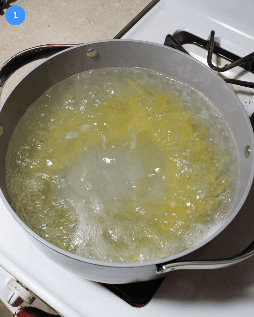Spaghetti boiling in a pot on the stove.