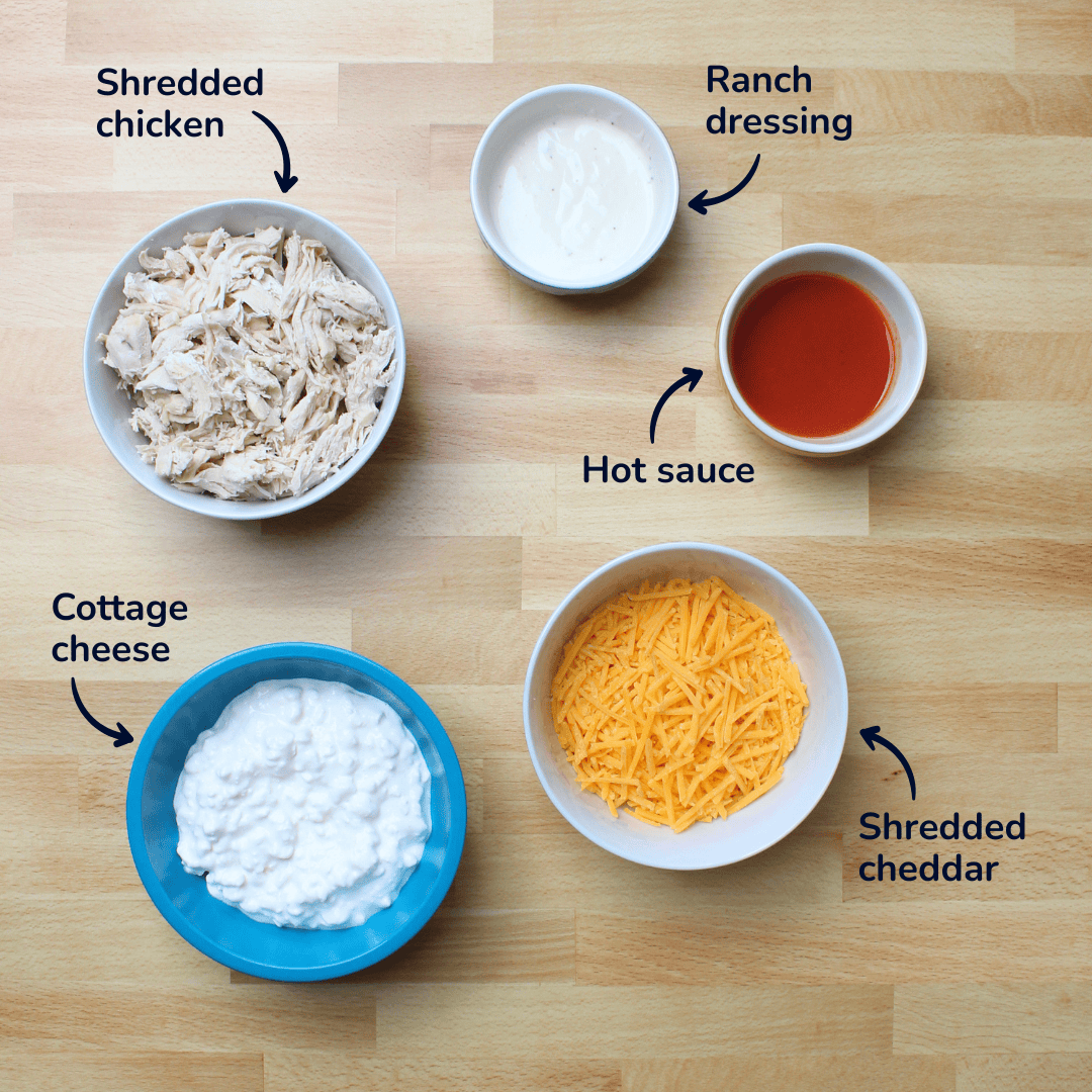 Ingredients for high protein buffalo chicken dip: shredded chicken, ranch dressing, hot sauce, shredded cheddar, and cottage cheese.