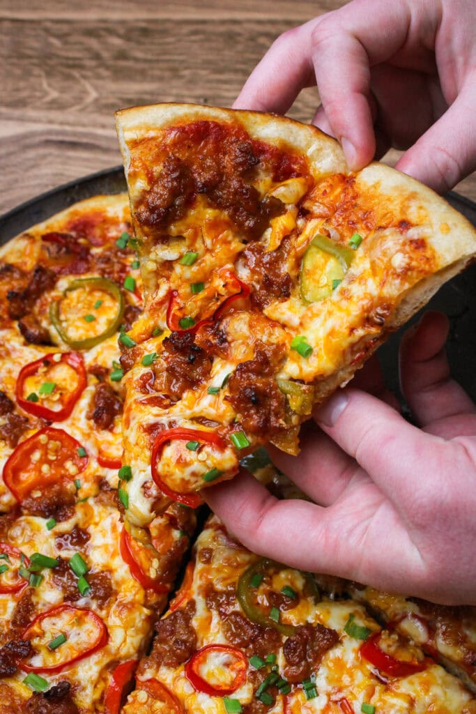 A hot slice of spicy sausage and cherry pepper pizza.