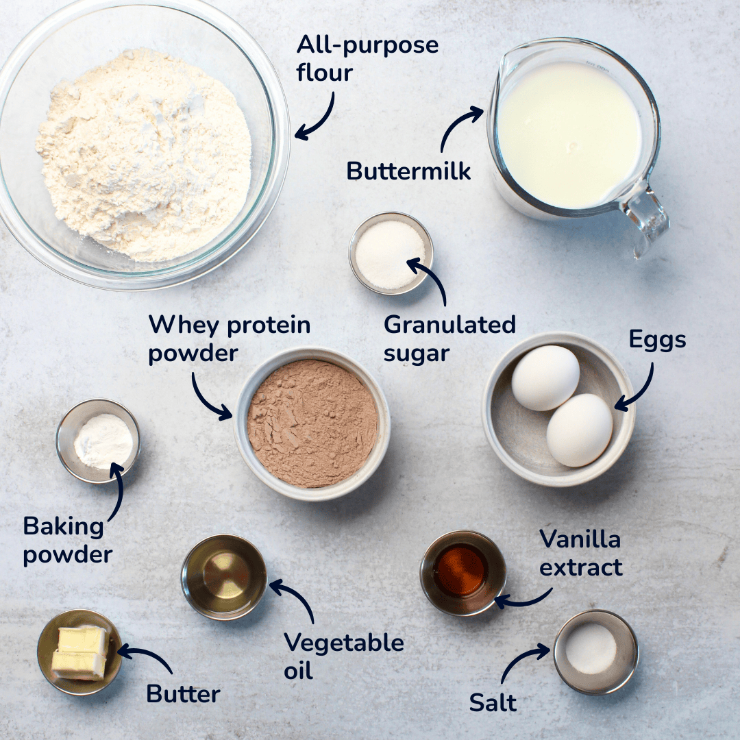 Ingredients for protein pancakes: all purpose flour, buttermilk, granulated sugar, eggs, whey protein powder, baking powder, vegetable oil, vanilla extract, salt, and butter.