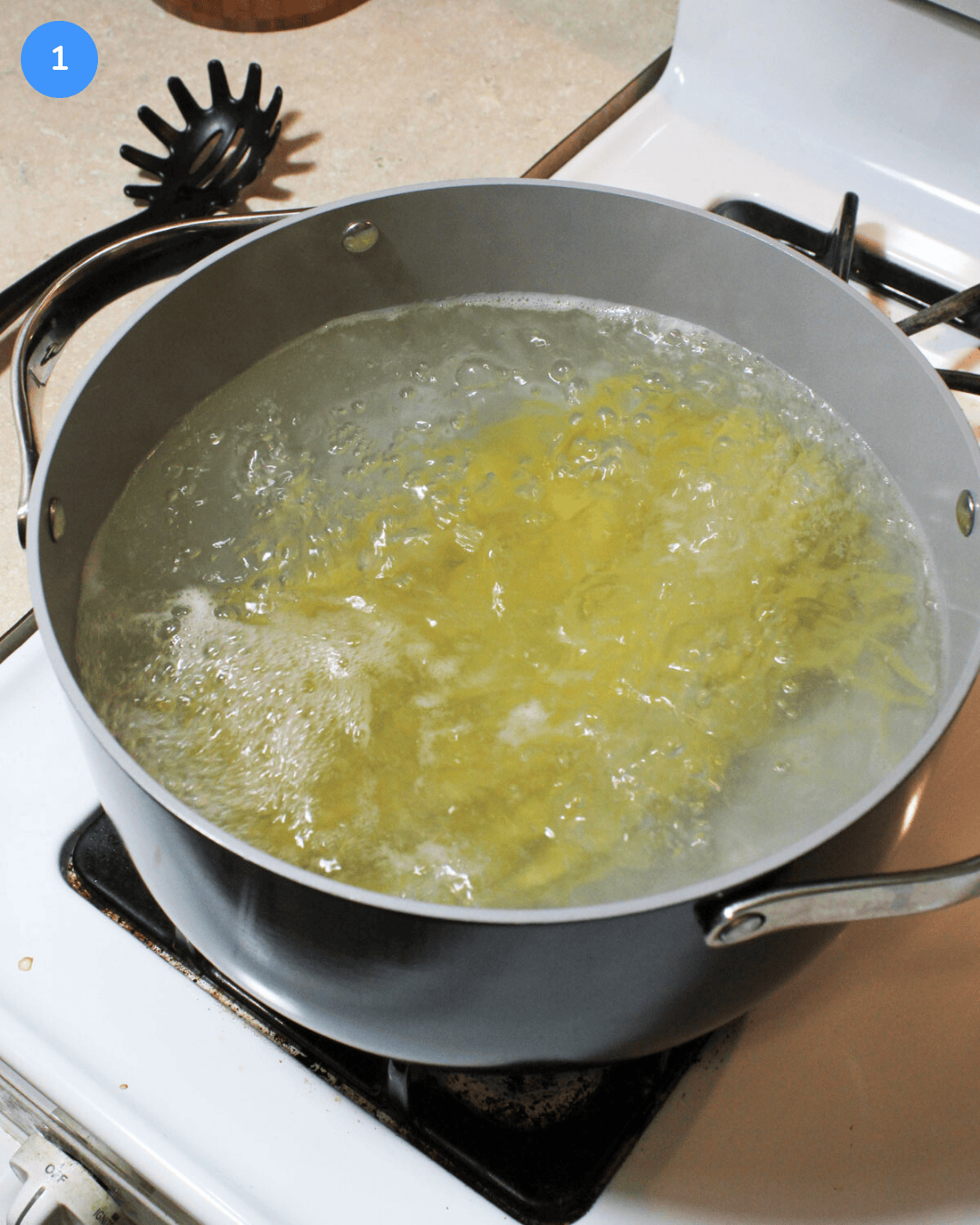 Linguine boiling in a pot of water on the stove.