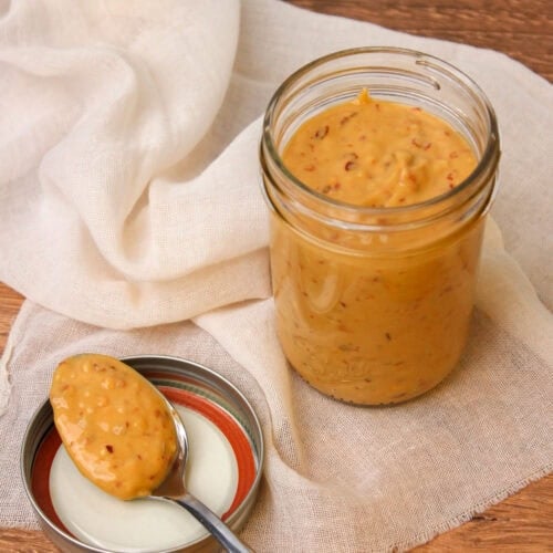 An open mason jar filled with freshly made spicy cashew dressing.