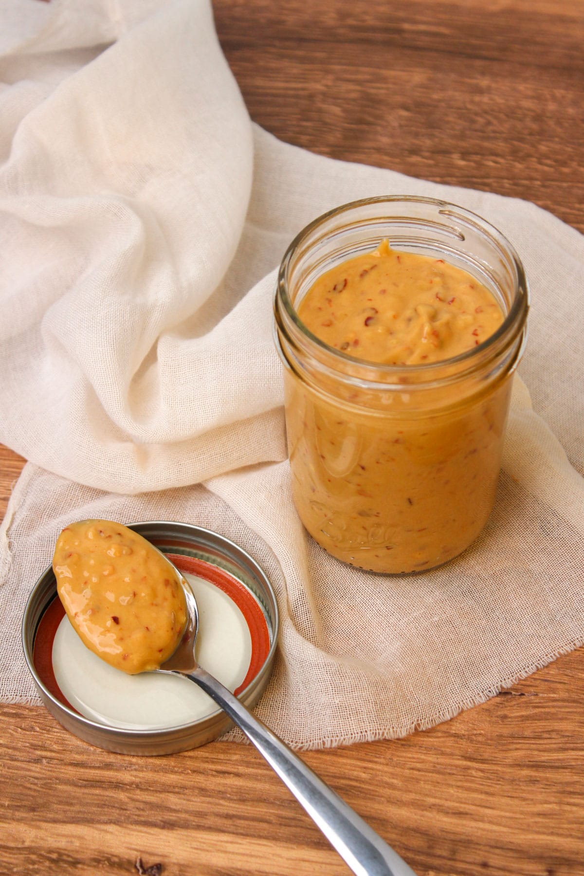 An open mason jar filled with freshly made spicy cashew dressing.