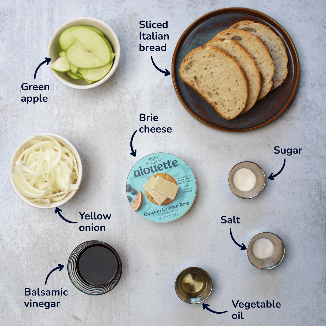 Ingredients for apple brie sandwich: sliced Italian bread, green apple, brie cheese, yellow onion, balsamic vinegar, vegetable oil, salt, and sugar.