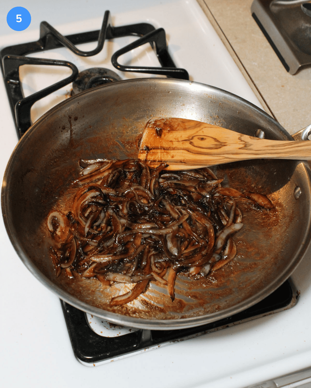 Balsamic caramelized onions in a stainless steel frying pan on the stove.
