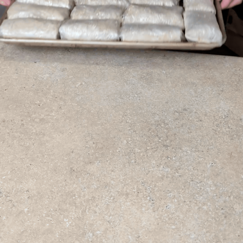 A sheet pan of plastic wrapped breakfast burritos from the freezer.