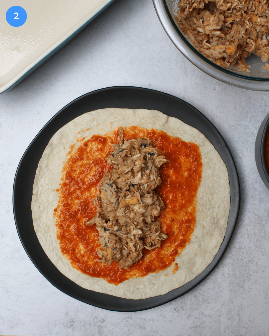 A 10-inch tortilla with ranchero sauce spread on it and piled high with burrito filling.